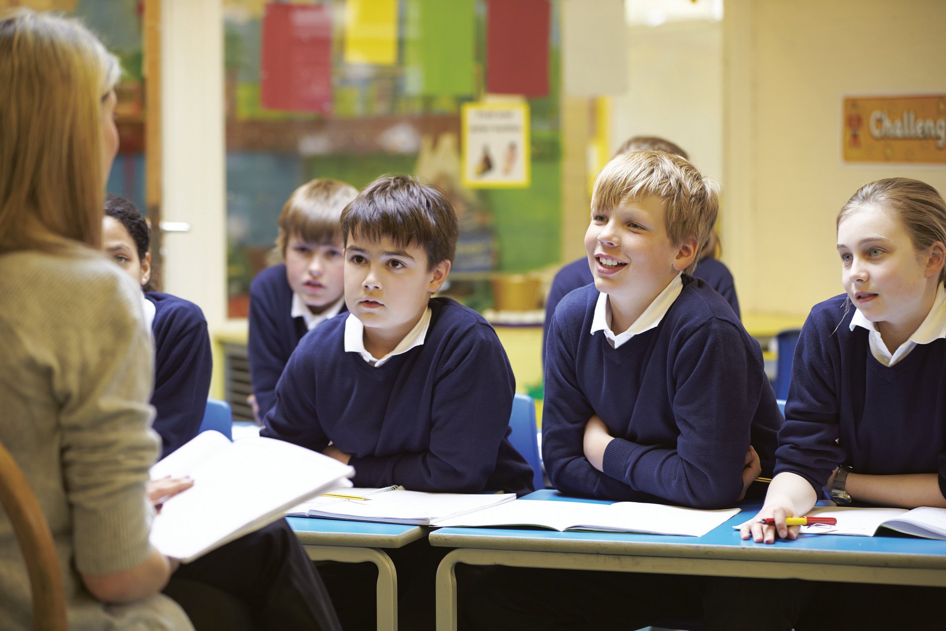 A group of children in class looking attentively at their teacher.